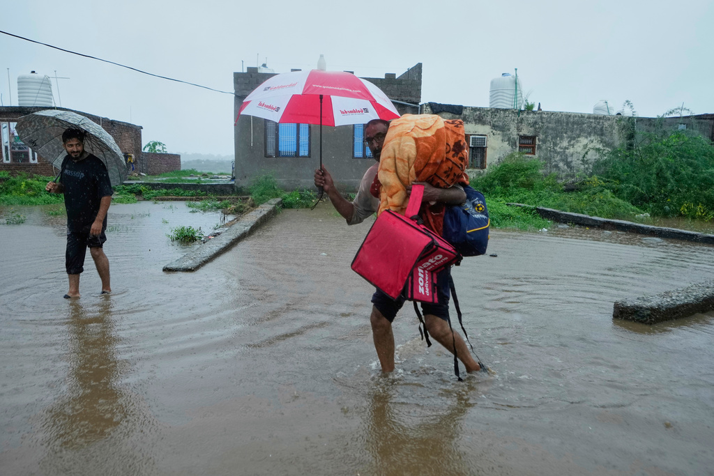People leave their homes and move to safer places after River Tawi started overflowing due to heavy rain Jammu, India, Tuesday, Aug. 26, 2025.(AP Photo/Channi Anand)