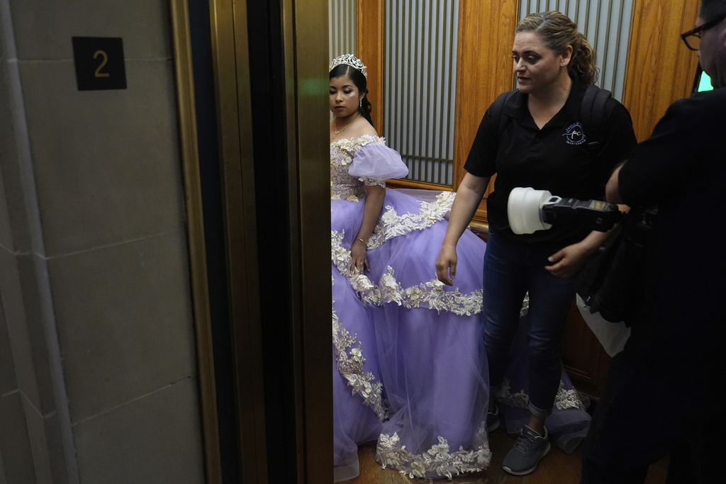Leyla Portillo gets into an elevator with videographer-photographer team Paola Soto and Cesar Lopez during her quinceañera portrait session at City Hall in San Francisco, Monday, April 28, 2025. (AP Photo/Jeff Chiu)