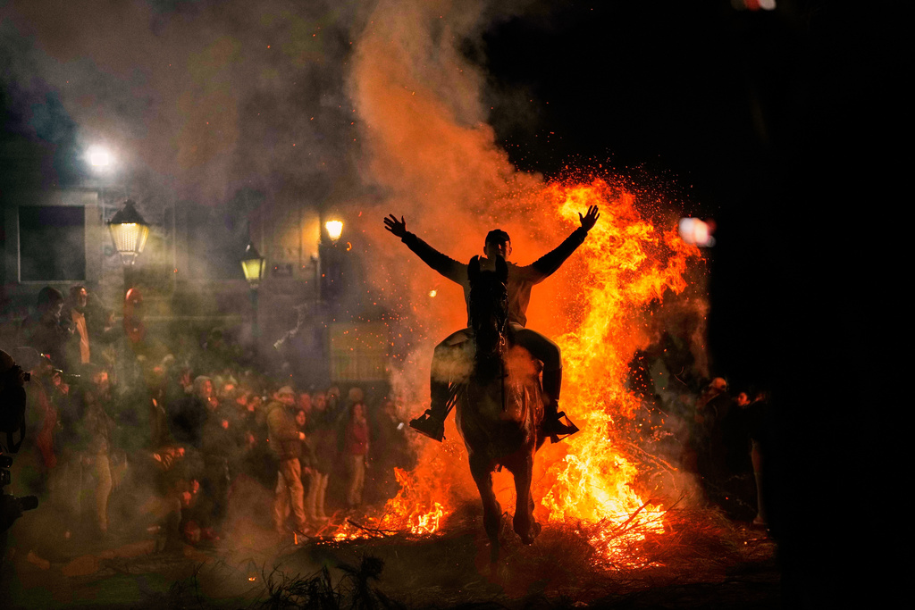 A man rides a horse through a bonfire as part of a ritual in honor of Saint Anthony the Abbot, the patron saint of domestic animals, in San Bartolome de Pinares, Spain, Friday, Jan. 16, 2026. (AP Photo/Manu Fernandez)