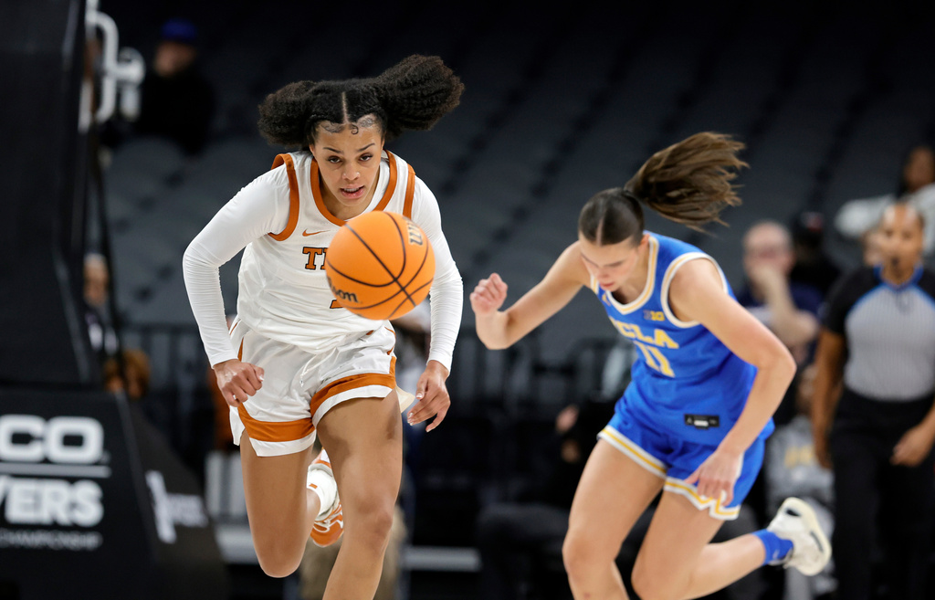 Texas guard Jordan Lee (7) and UCLA forward Gabriela Jaquez (11) chase after a loose ball during the first half of an NCAA college basketball game in the Players Era tournament Wednesday, Nov. 26, 2025, in Las Vegas. (AP Photo/Steve Marcus)