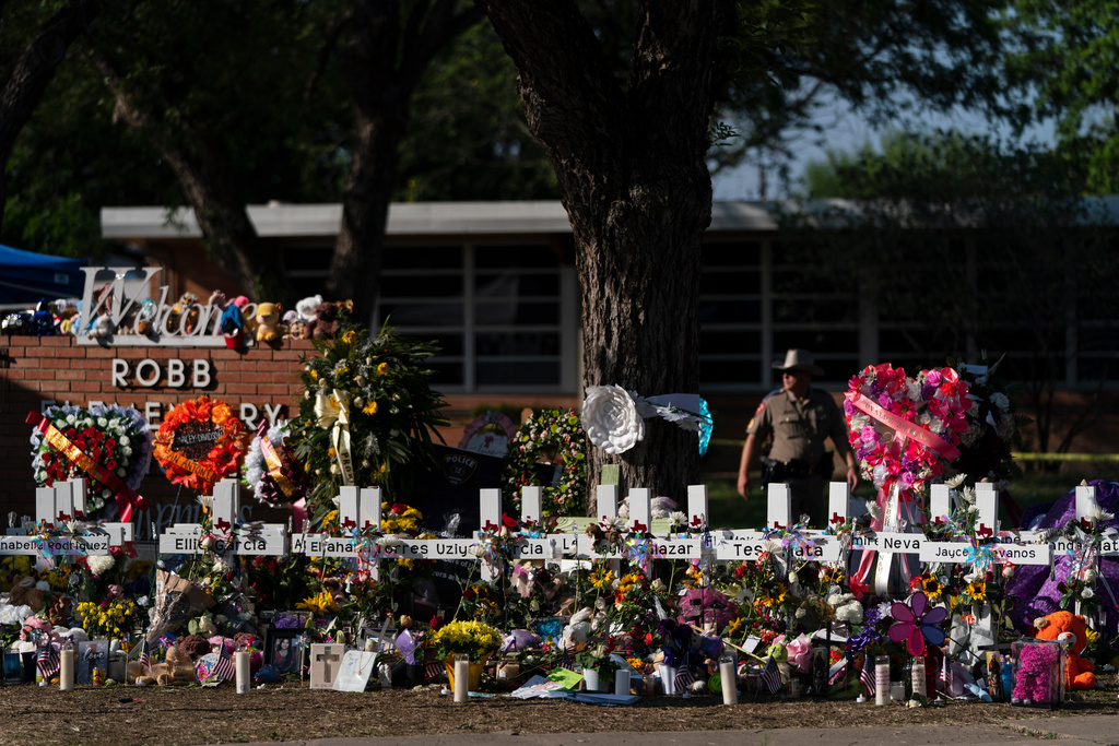 FILE - Flowers and candles are placed around crosses on May 28, 2022, at a memorial outside Robb Elementary School in Uvalde, Texas, to honor the victims killed in the school shooting. (AP Photo/Jae C. Hong, File)