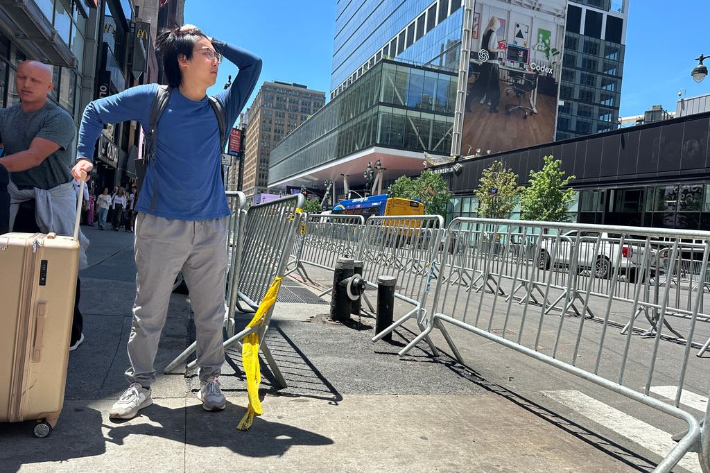 A traveler tries to navigate the area as stringent security measures are set up outside of Madison Square Garden in New York, Monday, June 8, 2026, as President Donald Trump is set to attend Game 3 of the NBA Finals basketball series between the New York Knicks and the San Antonio Spurs. (AP Photo/Ted Shaffrey)