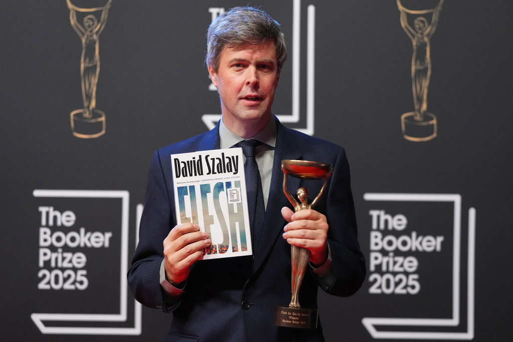 Hungarian-British author David Szalay poses for photographers with the trophy after winning the Booker Prize 2025 for his book 'Flesh' during a ceremony at Old Billingsgate in London, Monday, Nov. 10, 2025. (AP Photo/Kirsty Wigglesworth)