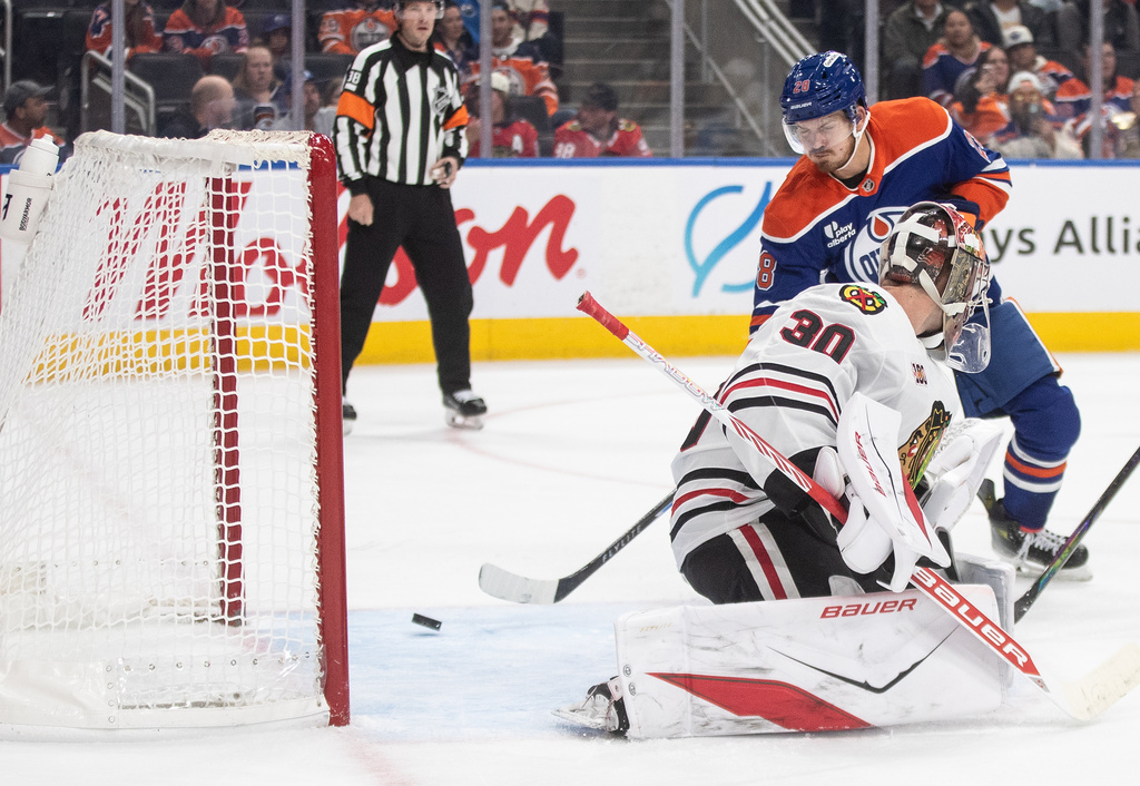 Chicago Blackhawks goalie Spencer Knight (30) is scored on by Edmonton Oilers' Jack Roslovic (28) during second period NHL action, in Edmonton on Saturday, Nov. 1, 2025. (Jason Franson/The Canadian Press via AP)