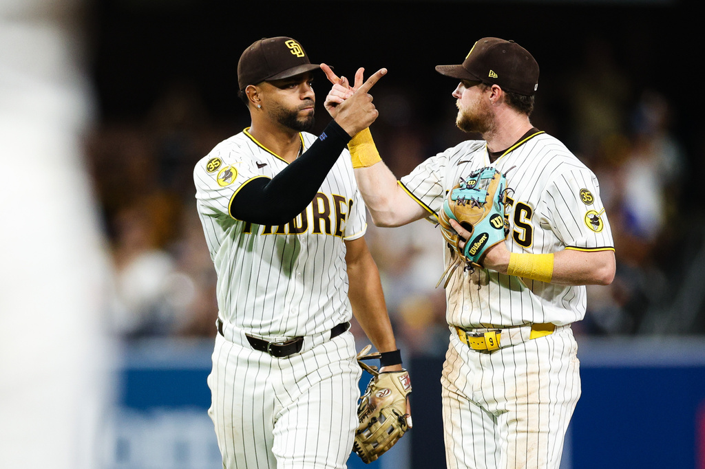 San Diego Padres' Jake Cronenworth, right, and Xander Bogaerts celebrate after turning a double play against the Toronto Blue Jays in the eighth inning of a baseball game Saturday, July 11, 2026, in San Diego. (AP Photo/Derrick Tuskan)
