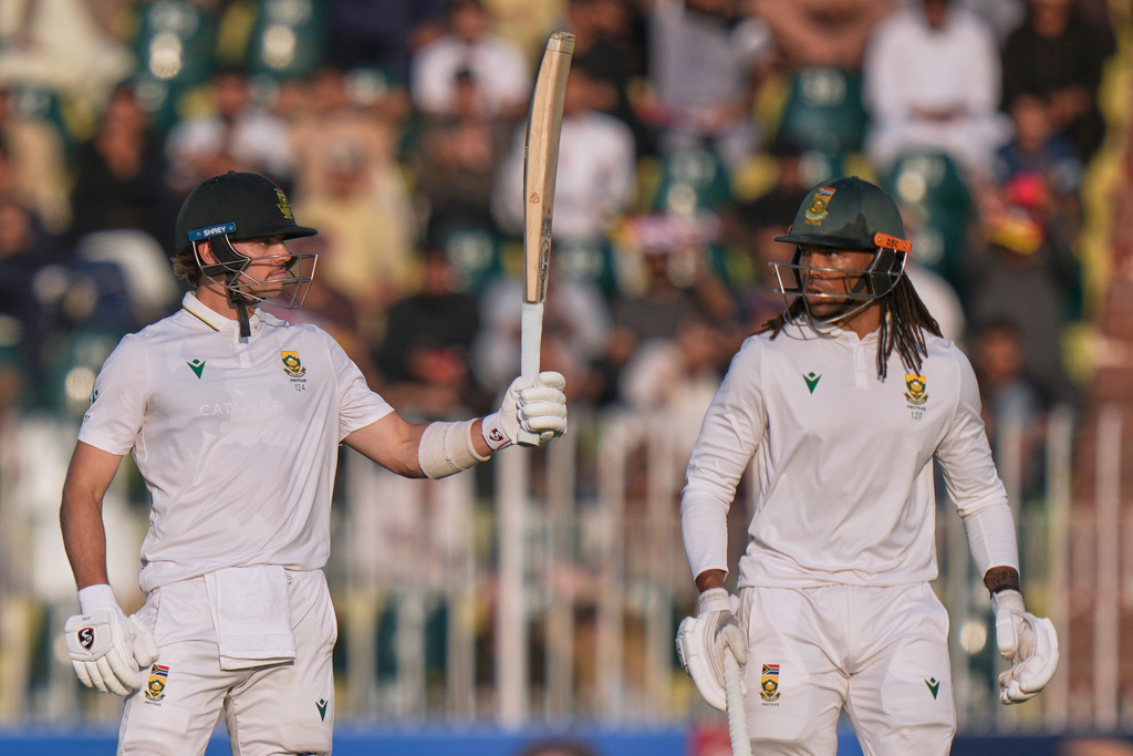 South Africa's Tristan Stubbs, left, celebrates after scoring fifty and Tony de Zorzi watches during the second day of the second test cricket match between Pakistan and South Africa, in Rawalpindi, Pakistan, Tuesday, Oct. 21, 2025. (AP Photo/Anjum Naveed)
