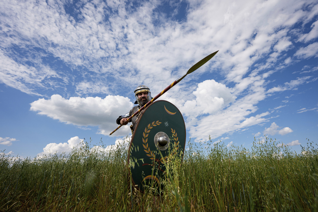 Andrej Miklanek of the Legio X Gemina Coh II, Roman era military historical group with members from the Czech Republic and Slovakia, strikes a pose in Poiana, Romania, Saturday, July 12, 2025, during the Getodava historical reenactment festival. (AP Photo/Andreea Alexandru)