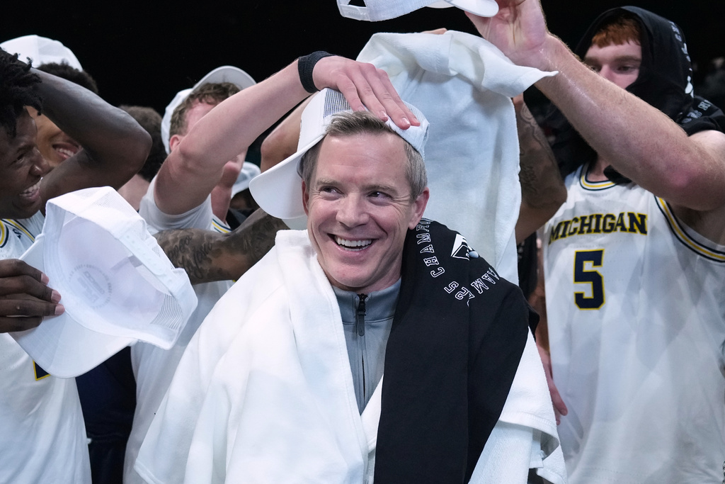 Michigan head coach Dusty May, center celebrates with his players after defeating Gonzaga in an NCAA college basketball game in the Players Era tournament in Las Vegas, Wednesday, Nov. 26, 2025. (AP Photo/Eric Gay)