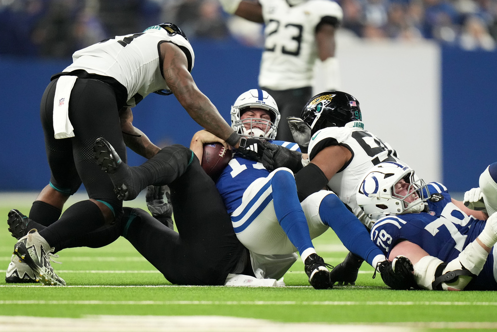 Indianapolis Colts quarterback Philip Rivers, left, is sacked by Jacksonville Jaguars defensive end Travon Walker, left, as defensive end Dawuane Smoot, right, gets in on the play during the second half of an NFL football game Sunday, Dec. 28, 2025, in Indianapolis. (AP Photo/AJ Mast)