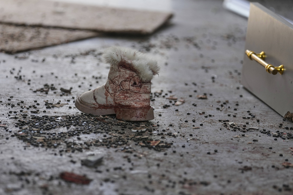 A bloodied shoe is seen among rubble at a beauty salon damaged in a deadly Iranian strike in the West Bank village of Beit Awa, near Hebron, Thursday, March 19, 2026. (AP Photo/Mahmoud Illean)