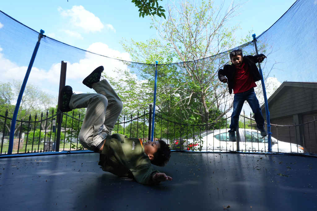 Ian Contreras, right, jumps on a trampoline with Jose Gonzalez after arriving home from school Thursday, April 9, 2026, in Fort Worth, Texas. (AP Photo/Julio Cortez)
