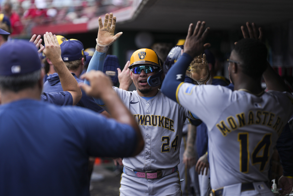 Milwaukee Brewers' William Contreras celebrates in the dugout after hitting a home run in the ninth inning of a baseball game against the Cincinnati Reds, Sunday, Aug. 17, 2025, in Cincinnati. (AP Photo/Grace Bradley)