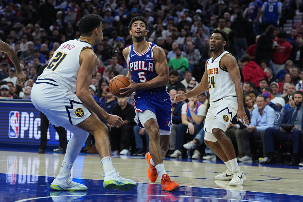 Philadelphia 76ers' Quentin Grimes (5) goes up to shoot against Denver Nuggets' Spencer Jones (21) and Jalen Pickett (24) during the first half of an NBA basketball game Monday, Jan. 5, 2026, in Philadelphia. (AP Photo/Matt Rourke)