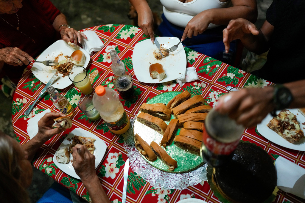 Christmas dinner is served at the home of Abraham Castro's parents in Maracay, Venezuela, early Thursday, Dec. 25, 2025. Castro and his partner Mariela Gómez, a Venezuelan migrant couple who abandoned their journey to the United States following thPresident Donald Trump's immigration crackdown, are spending the holiday there after returning home. (AP Photo/Matias Delacroix)