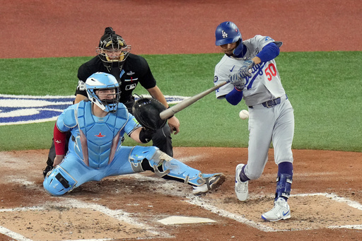 Los Angeles Dodgers' Mookie Betts (50) hits a two-run single against the Toronto Blue Jays during the third inning in Game 6 of baseball's World Series in Toronto on Friday, Oct. 31, 2025. (Chris Young/The Canadian Press via AP) Los Angeles Dodgers' Mookie Betts (50) hits a two-run single against the Toronto Blue Jays during the third inning in Game 6 of baseball's World Series in Toronto on Friday, Oct. 31, 2025. (Chris Young/The Canadian Press via AP)
