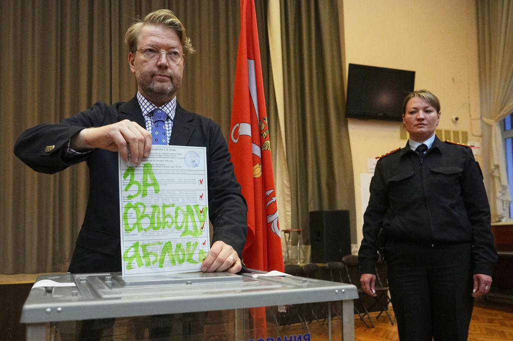 Yabloko party leader Nikolai Rybakov casts a ballot with a writing in Russian reading "For freedom" during the parliamentary election in St. Petersburg, Russia, Sunday, Sept. 20, 2026. (AP Photo/Dmitri Lovetsky)