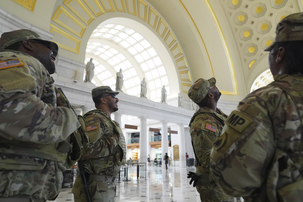 National Guard personnel look up and admire the valuted ceiling as they keep watch as travelers arrive at Union Station near the Capitol, in Washington, Friday, Aug. 15, 2025, in Washington. (AP Photo/Jacquelyn Martin)