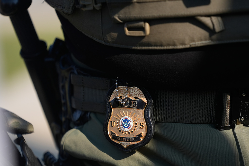 The badge of a Immigration and Customs Enforcement agent is shown near an Immigration and Customs Enforcement facility in Broadview, Ill., Friday, Oct. 3, 2025. (AP Photo/Erin Hooley)