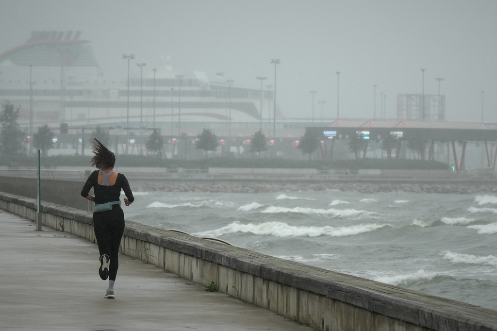 A jogger runs at the beach along the Tallinn bay of the Baltic sea on a rainy and windy day in Tallinn, Estonia, Sunday, Aug. 23, 2026. (AP Photo/Sergei Grits)