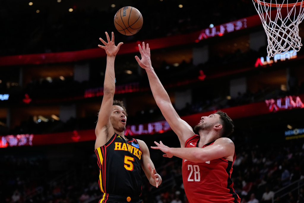 Atlanta Hawks guard CJ McCollum (3) shoots against Houston Rockets center Alperen Sengun (28) during the first half of an NBA basketball game in Houston, Friday, March 20, 2026. (AP Photo/Ashley Landis)