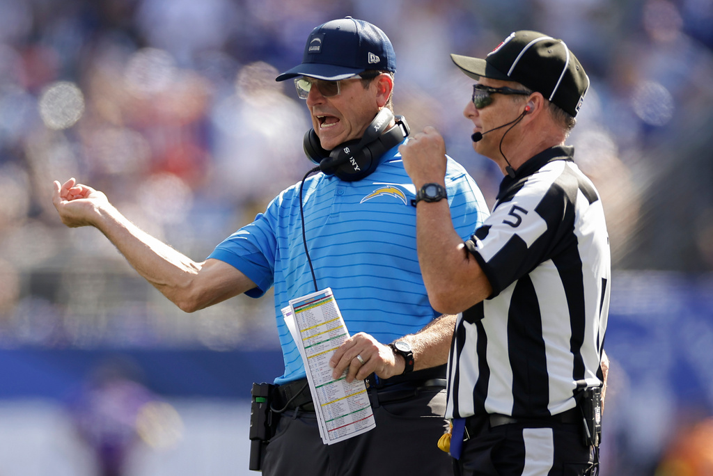 Los Angeles Chargers head coach Jim Harbaugh talks with side judge Jim Quirk (5) during the second quarter of an NFL football game, Sunday, Sept. 28, 2025, in East Rutherford, N.J. (AP Photo/Adam Hunger)
