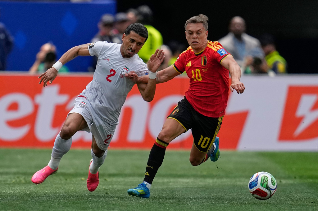 Iran's Saleh Hardani (2), left, fights for the ball with Belgium's Leandro Trossard (10) during the World Cup Group G soccer match between Belgium and Iran in Inglewood, Calif., near Los Angeles, Sunday, June 21, 2026. (AP Photo/Gregory Bull)