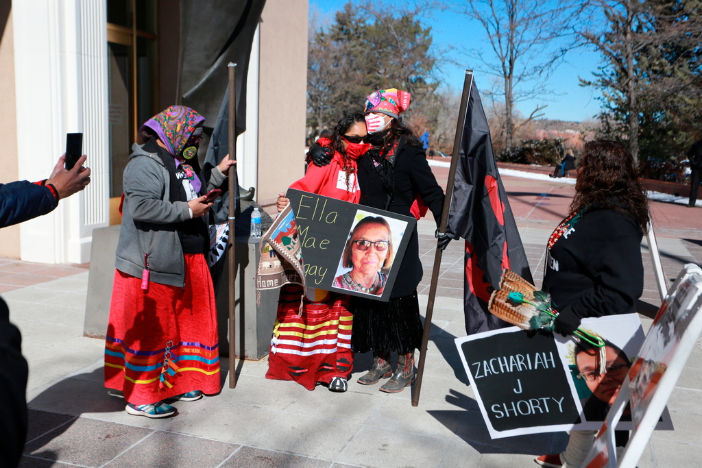 FILE - Seraphine Warren, center left, is embraced by state New Mexico state Sen. Shannon Pinto while holding a poster with Warren's aunt Ella Mae Begay's photo on it outside the state capitol building Feb. 4, 2022, in Santa Fe, N.M. (AP Photo/Cedar Attanasio, File)