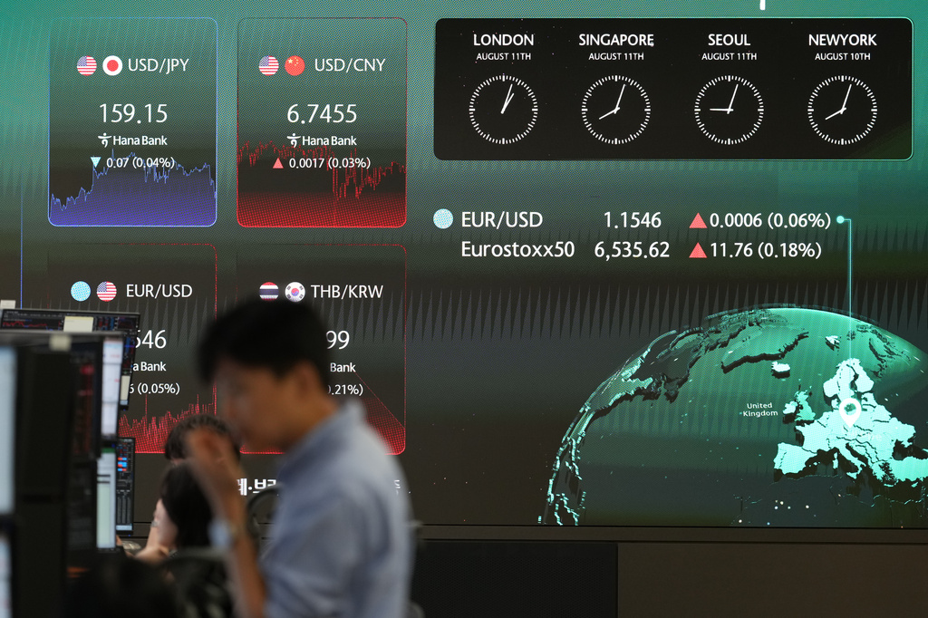 A dealer stands near the screens showing the foreign exchange rates at a dealing room of Hana Bank in Seoul, South Korea, Tuesday, Aug. 11, 2026. (AP Photo/Lee Jin-man)