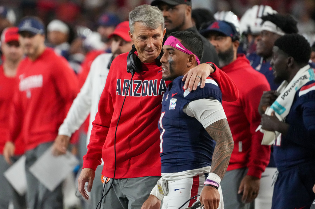 Arizona head coach Brent Brennan, left, shares a moment with quarterback Noah Fifita, right, during an NCAA college football game against Iowa State during the second half Saturday, Oct. 24, 2026, in Tucson, Ariz. (AP Photo/Darryl Webb)