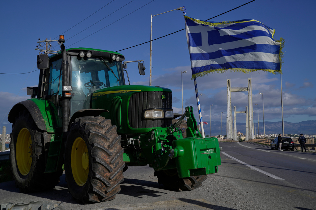 A tractor with a Greek flag blocks the Chalkida Bridge as farmers protest over delays in European Union–backed agricultural subsidy payments, on Evia island, Greece, Thursday, Jan. 8, 2026. (AP Photo/Thanassis Stavrakis)