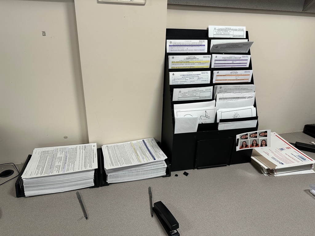 A stack of blank passport applications sits on a desk at the Otis Library on Friday, Feb. 13, 2026 in Norwich, Conn. (AP Photo/Susan Haigh)
