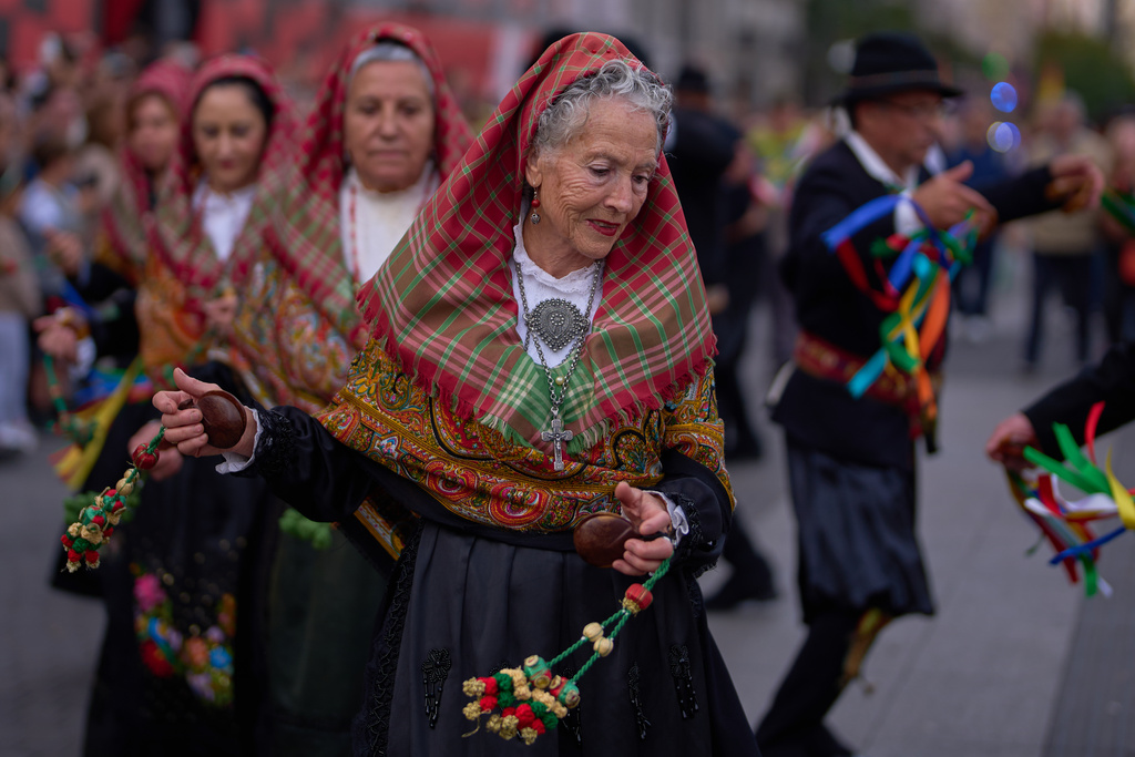 People in regional traditional costumes take part in the herding of sheep through central Madrid, Spain, as shepherds lead the animals through the streets in defense of ancient grazing and migration rights, Sunday, Oct. 19, 2025. (AP Photo/Manu Fernandez)