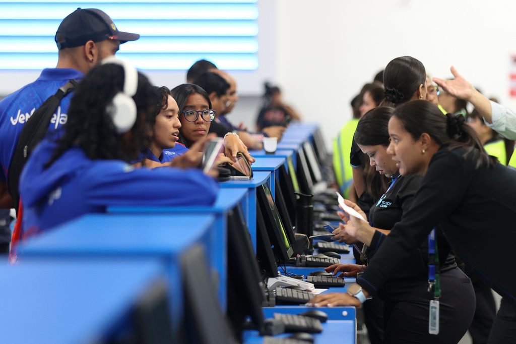 Passengers check in at Simon Bolivar International Airport as it reopens to commercial flights two months after closing due to the earthquake in Maiquetia, Venezuela, Tuesday, Sept. 1, 2026. (AP Photo/Pedro Mattey)
