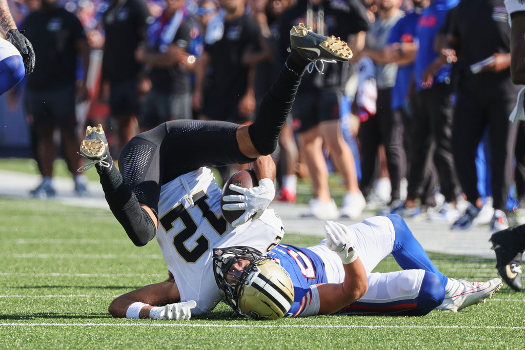 New Orleans Saints wide receiver Chris Olave (12) is brought down by Buffalo Bills safety Cole Bishop in the second half of an NFL football game, Sunday, Sept. 28, 2025, in Orchard Park, N.Y. (AP Photo/Jeffrey T. Barnes)