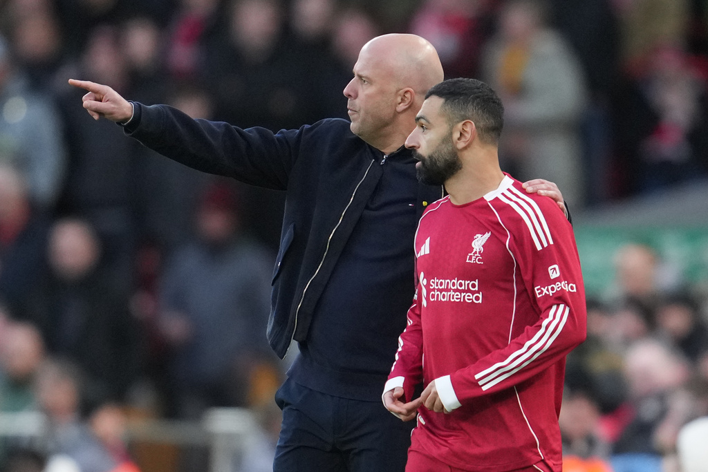 FILE - Liverpool's manager Arne Slot talks to Mohamed Salah during the Premier League soccer match between Liverpool and Tottenham in Liverpool, England, Sunday, March 15, 2026. (AP Photo/Jon Super, File)