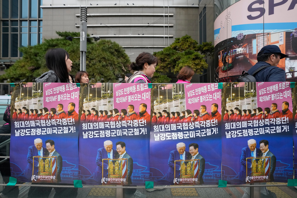 Posters showing images of U.S. President Donald Trump and South Korean President Lee Jae Myung are seen at a subway gate during a rally against the government's labor policy and U.S. President Donald Trump's tariffs policy on South Korea, in Seoul, Saturday, Nov. 8 2025. The signs read "Stop the unprecedented negotiations! and Withdraw of US troops!" (AP Photo/Ahn Young-joon)