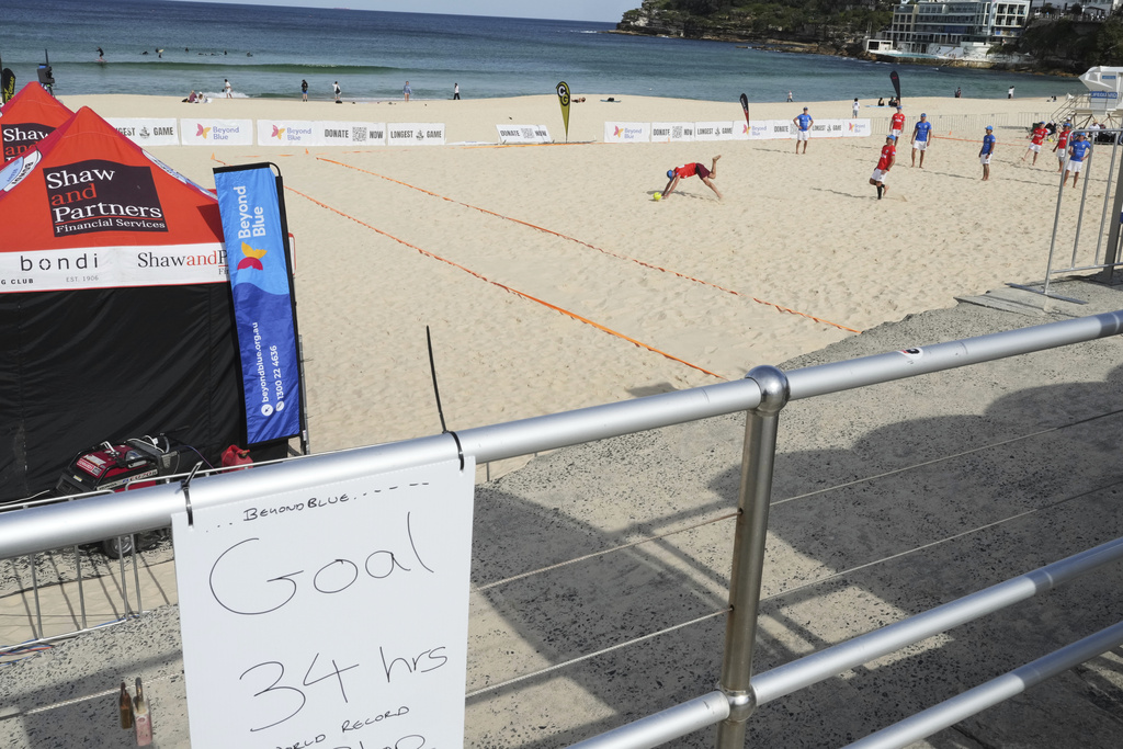 A player falls during a world record attempt for a game of beach touch rugby on Bondi Beach in Sydney, Australia, Thursday, Sept. 4, 2025. (AP Photo/Mark Baker)