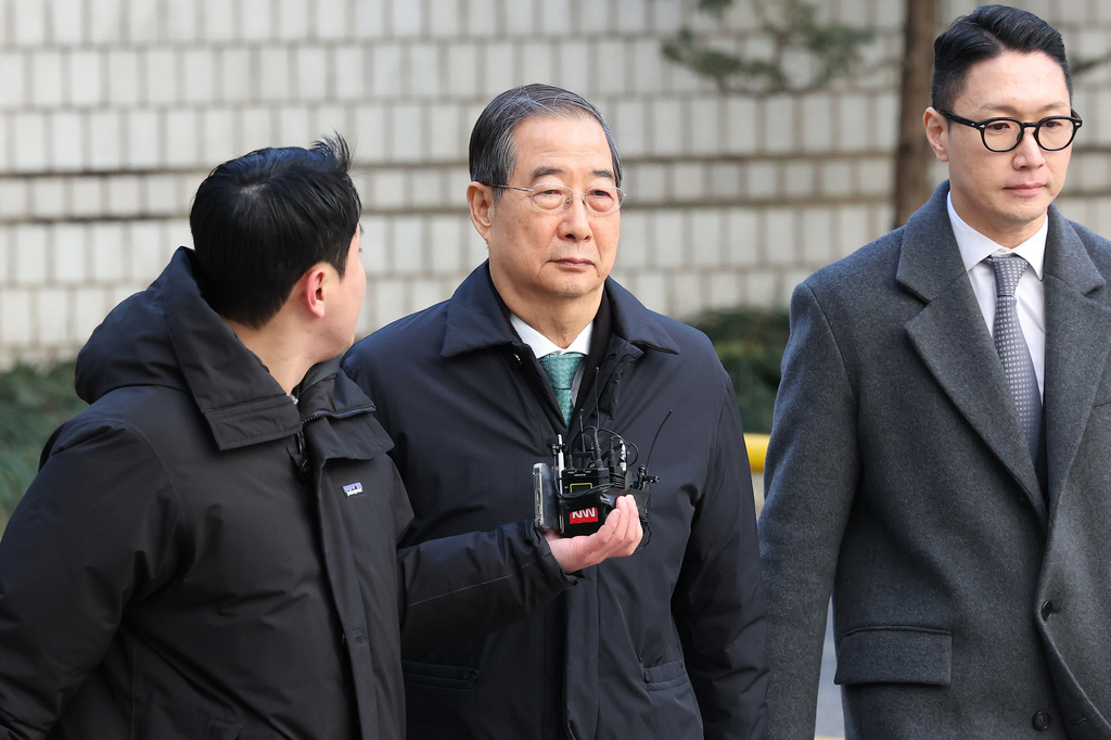 Former South Korean Prime Minister Han Duck-soo, center, arrives at the Seoul Central District Court for his first sentencing trial in the insurrection case, in Seoul Wednesday, Jan. 21, 2026. (Chung Sung-Jun/Pool Photo via AP)