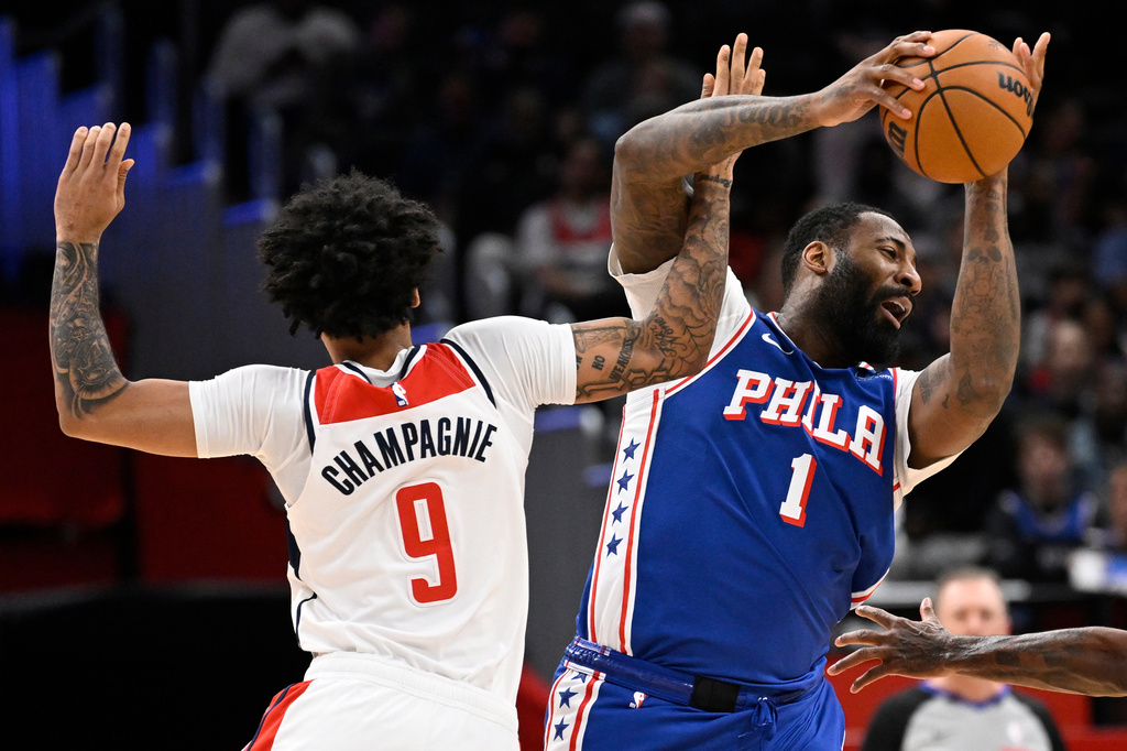 Washington Wizards forward Justin Champagnie collides Philadelphia 76ers center Andre Drummond (1) during the first half of an NBA basketball game, Wednesday, April 1, 2026, in Washington. (AP Photo/John McDonnell)