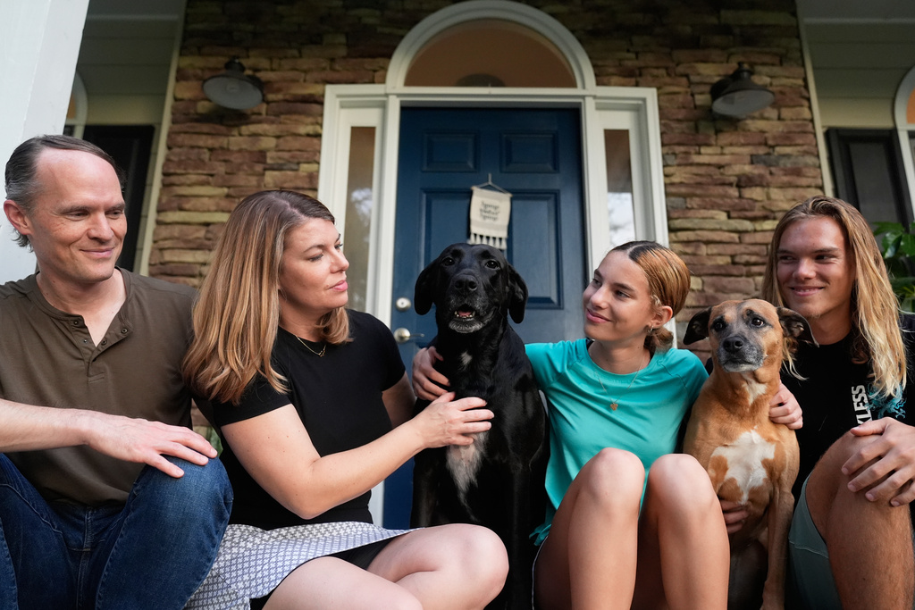 Meaghan and Chris Marr pose with their children and dogs for a photograph on Thursday, Sept. 25, 2025, in Cartersville, Ga. (AP Photo/Brynn Anderson)