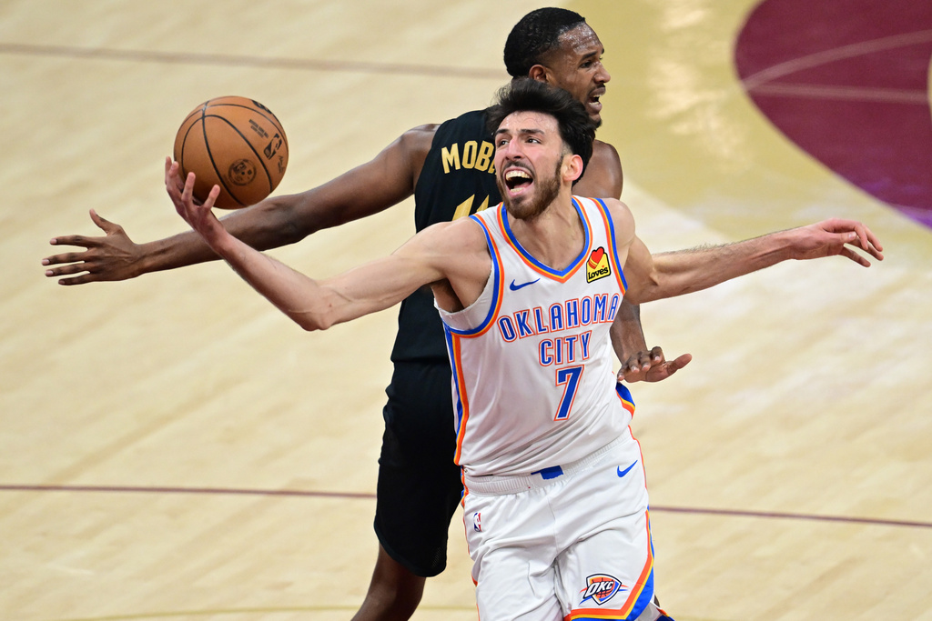 Oklahoma City Thunder center Chet Holmgren (7) spins to the basket while being fouled by Cleveland Cavaliers center Evan Mobley, back, Monday, Jan. 19, 2026, in Cleveland. (AP Photo/David Dermer)
