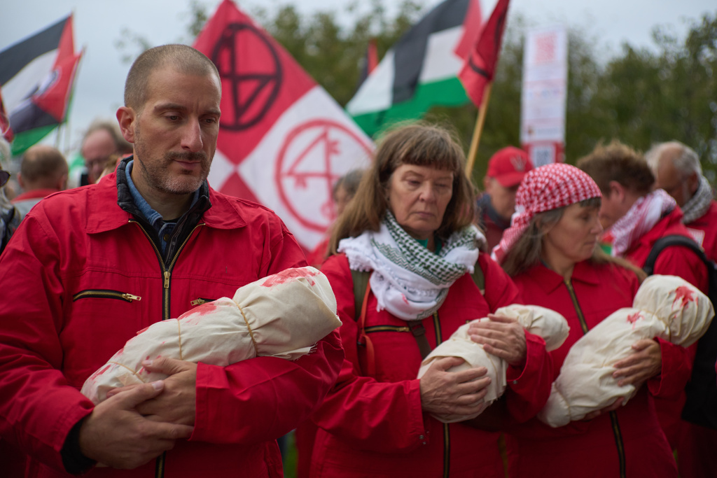 Protesters mimick holding the bodies of children demanding their government do more to halt Israel's campaign in Gaza, during a demonstration in Amsterdam, Netherlands, Sunday, Oct. 5, 2025. (AP Photo/Peter Dejong)
