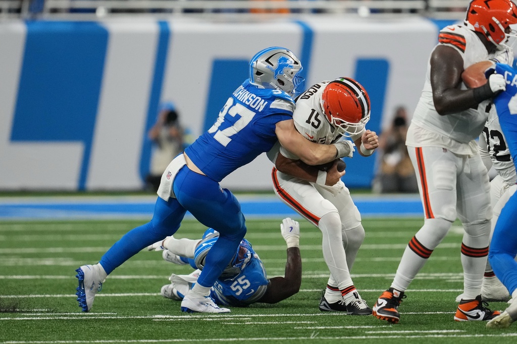Cleveland Browns quarterback Joe Flacco (15) is sacked by Detroit Lions defensive end Aidan Hutchinson (97) during the second half of an NFL football game, Sunday, Sept. 28, 2025, in Detroit. (AP Photo/Paul Sancya)