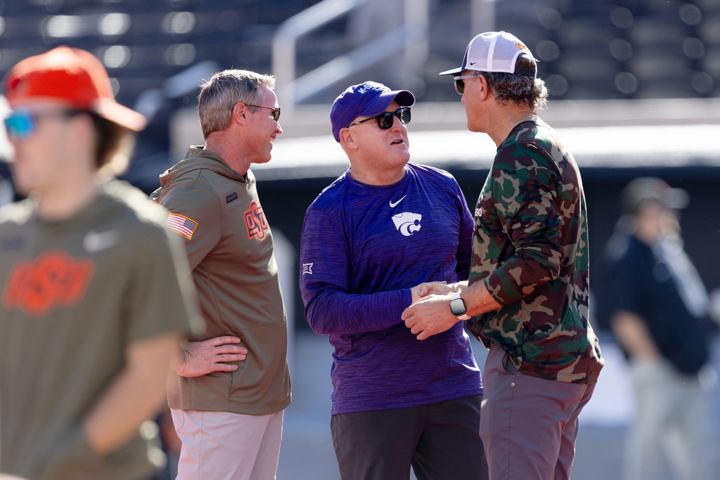 Kansas State head coach Chris Klieman, center, shakes hands with Oklahoma State head coach Doug Meacham before an NCAA college football game Saturday, Nov. 15, 2025, in Stillwater, Okla. (AP Photo/Mitch Alcala)