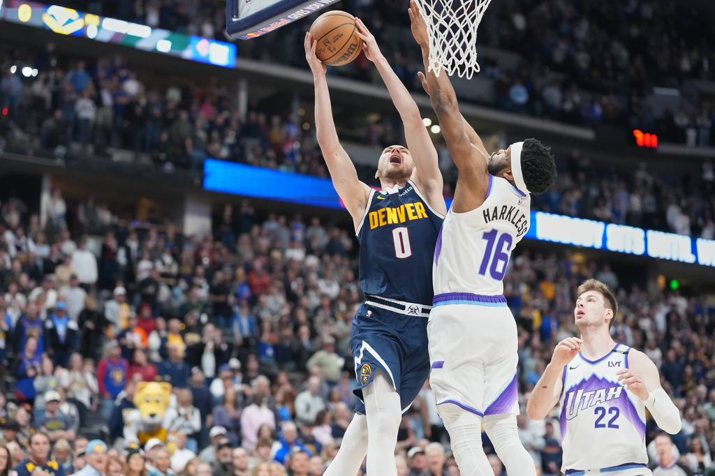 Denver Nuggets guard Christian Braun (0) has his shot blocked by Utah Jazz guard Elijah Harkless (16) as Jazz center Kyle Filipowski (22) watches in the first half of an NBA basketball game Friday, March 27, 2026, in Denver. (AP Photo/David Zalubowski)
