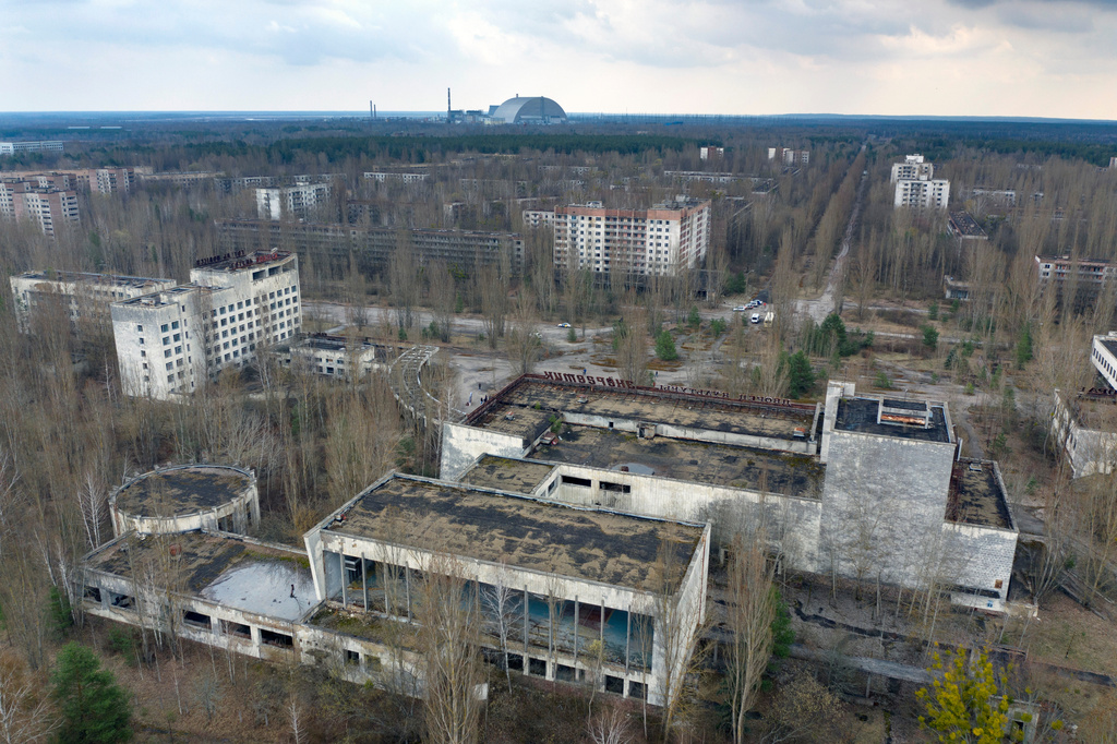 FILE - A dome-shaped shelter covering the damaged reactor at the Chernobyl nuclear plant is seen on the horizon, April 15, 2021, from the abandoned town of Pripyat, Ukraine, once home to some 50,000 people whose lives were connected to the plant. (AP Photo/Efrem Lukatsky, File)