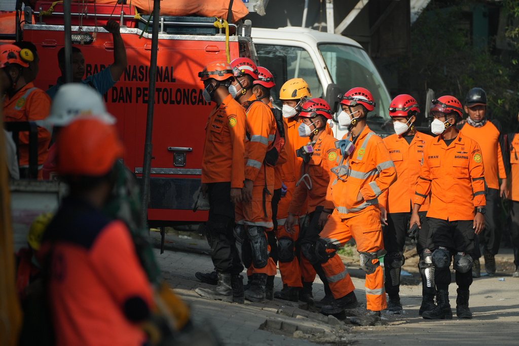 Rescuers gather outside the islamic boarding school where a building collapsed as the search for missing people is underway in Sidoarjo, East Java, Indonesia, Saturday, Oct. 4, 2025. (AP Photo/Achmad Ibrahim)