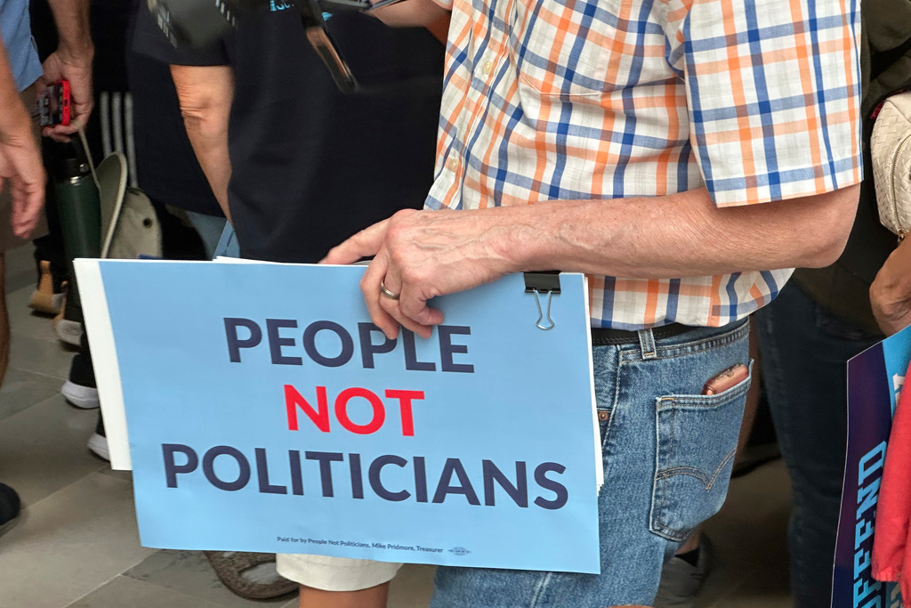 A protestor holds a sign in opposition to a plan redrawing Missouri's U.S. House districts during a rally at the state Capitol, Friday, Sept. 12, 2025, in Jefferson City, Mo. (AP Photo/David A. Lieb)