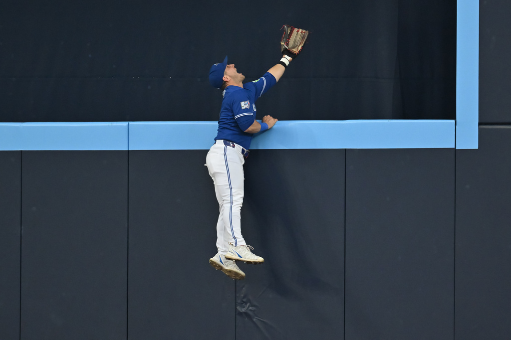 Toronto Blue Jays outfielder Daulton Varsho is unable to catch a home run off the bat of Tampa Bay Rays' Victor Mesa Jr. during the second inning of a baseball game in Toronto, Monday, July 20, 2026. (Jon Blacker/The Canadian Press via AP)