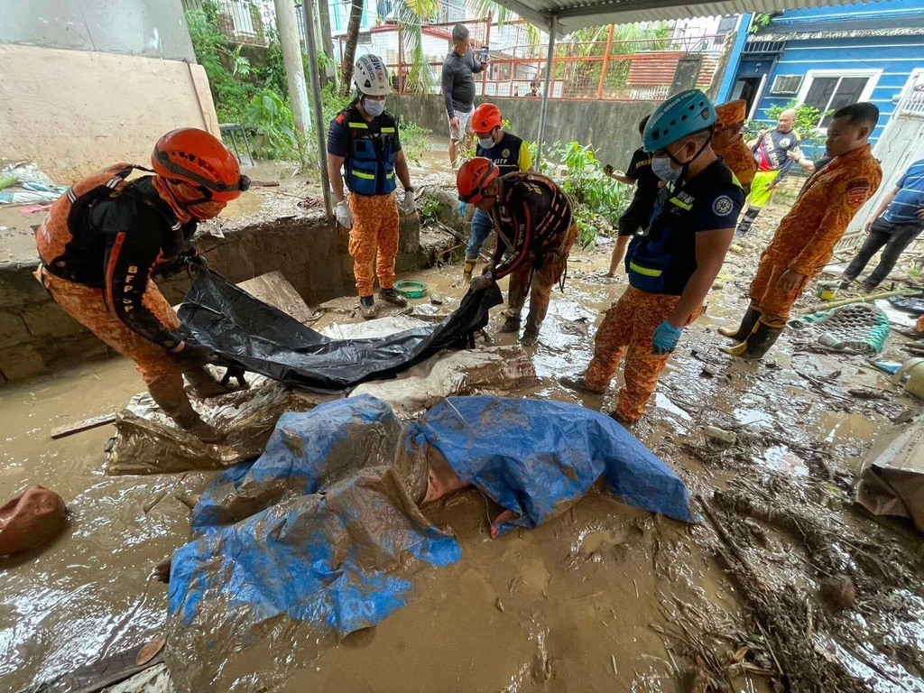 EDS NOTE: GRAPHIC CONTENT - Rescue workers prepare to carry away a dead body after flooding caused by Typhoon Kalmaegi in Cebu city, central Philippines, Tuesday, Nov. 4, 2025. (AP Photo/Jacqueline Hernandez)